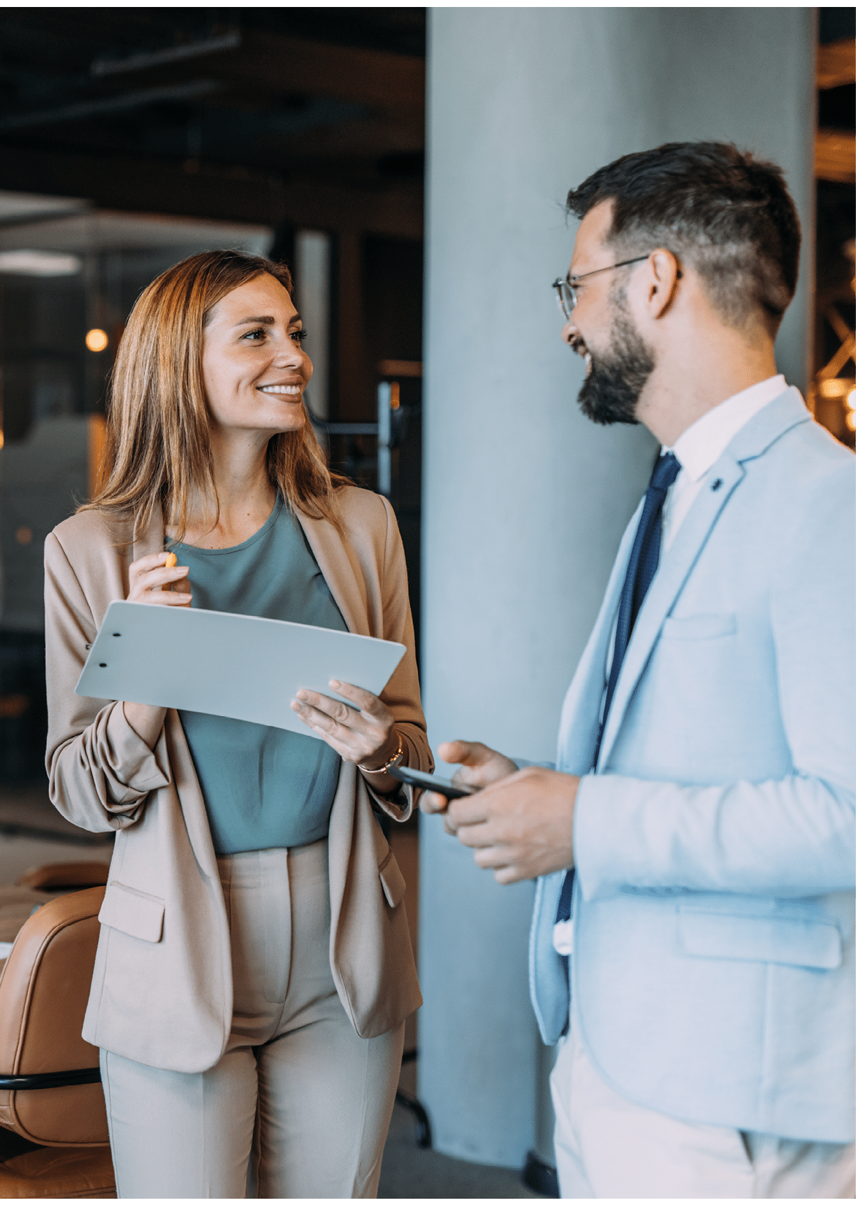 Shot of two coworkers having a discussion in modern office. Businessman and businesswoman in meeting discussing important financial documents. Confident business people working together in the office. Corporate business persons discussing new project and sharing ideas in the workplace.